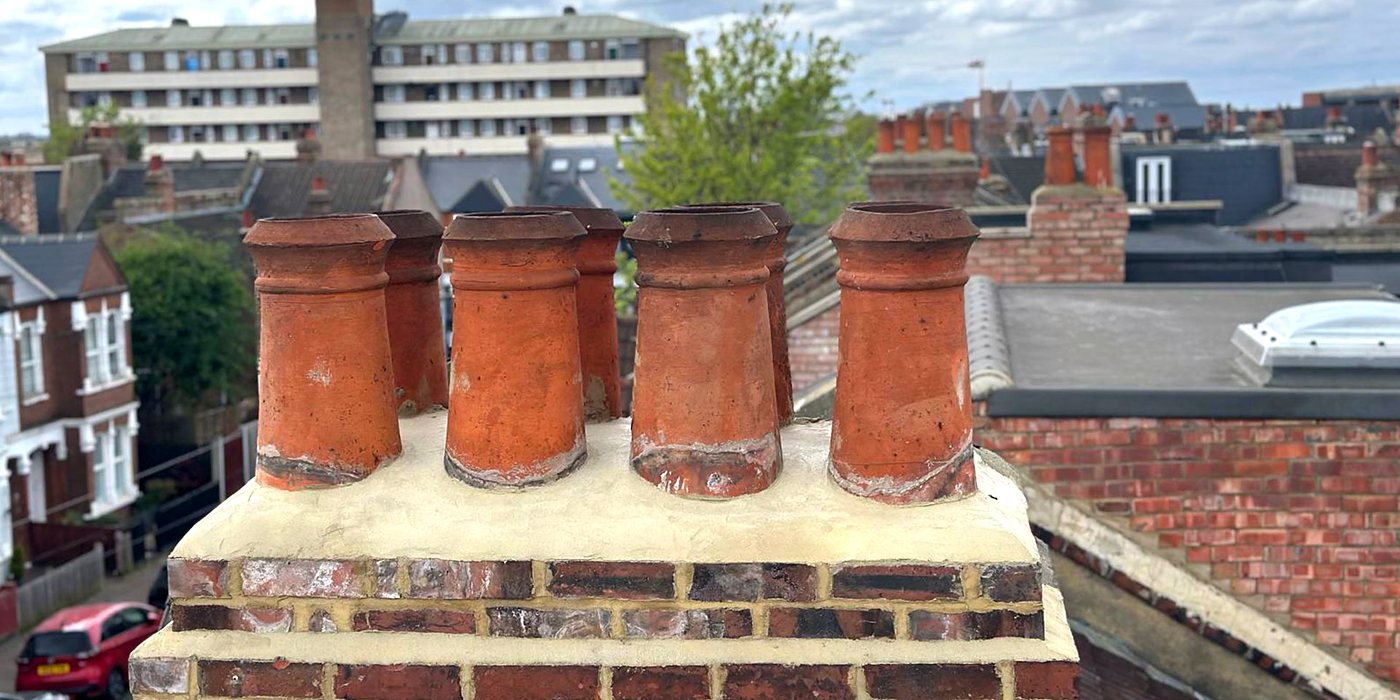 Clay chimney pots on a rebuilt stack above the rooftops of a South London terrace