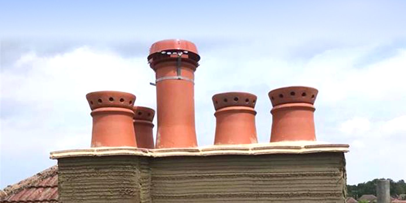 A rebuilt chimney stack with five new clay pots