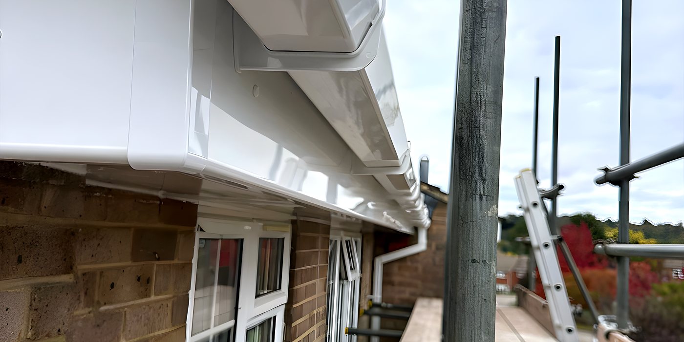 New white fascia board and vented soffit, seen from the scaffold