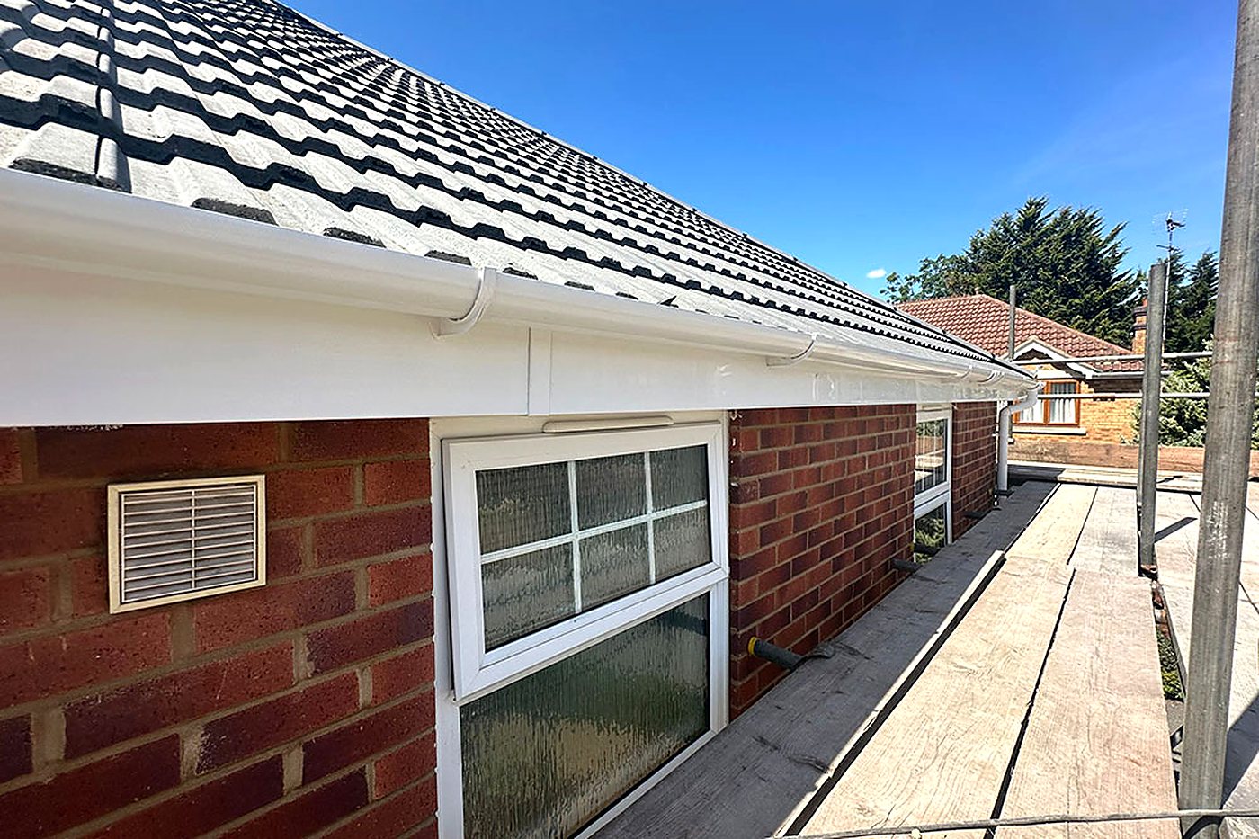 The eaves of a bungalow under grey concrete interlocking tiles