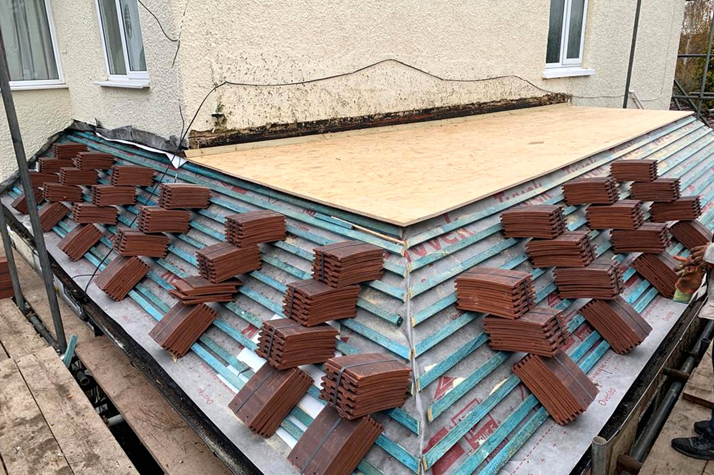 New tiles stacked on the battens, ready to lay