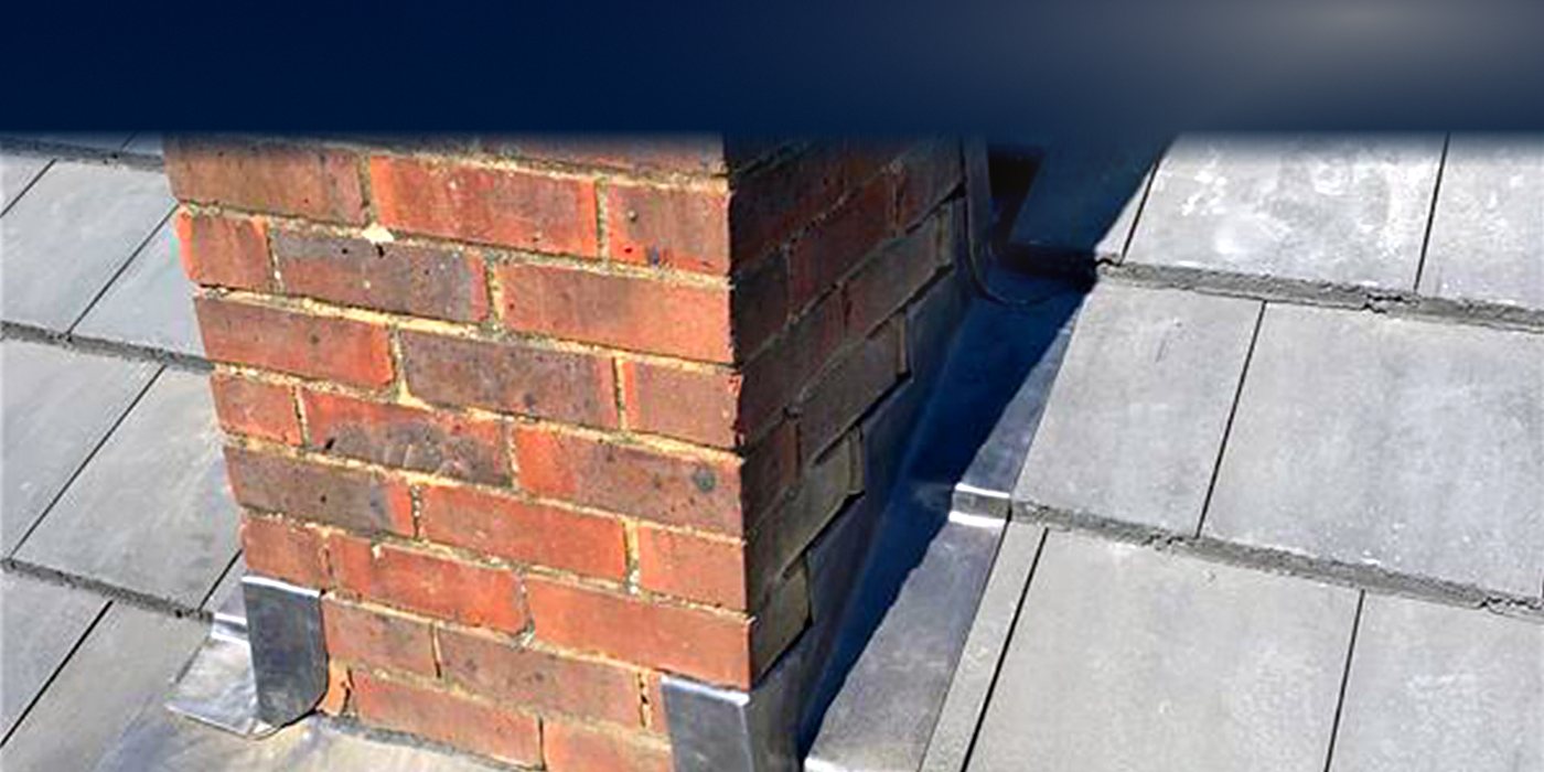 Roofing work in Balham: a brick chimney stack with new lead flashing on a slate roof