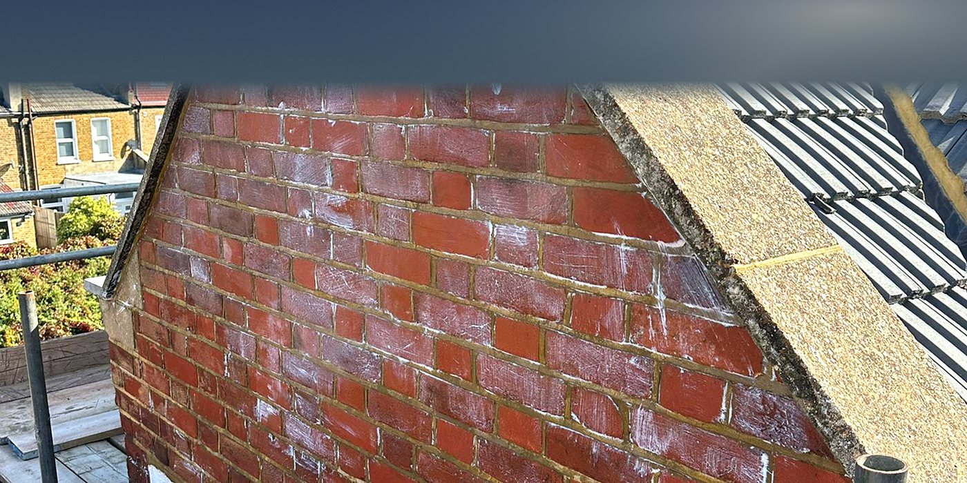 Roofing work in Epsom: a brick chimney stack beside a rendered wall
