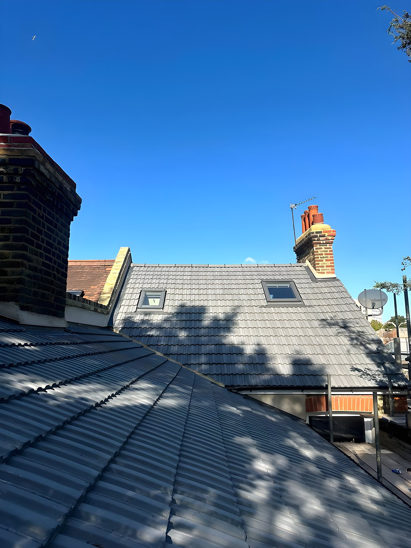 A finished roof, chimney and the street beyond